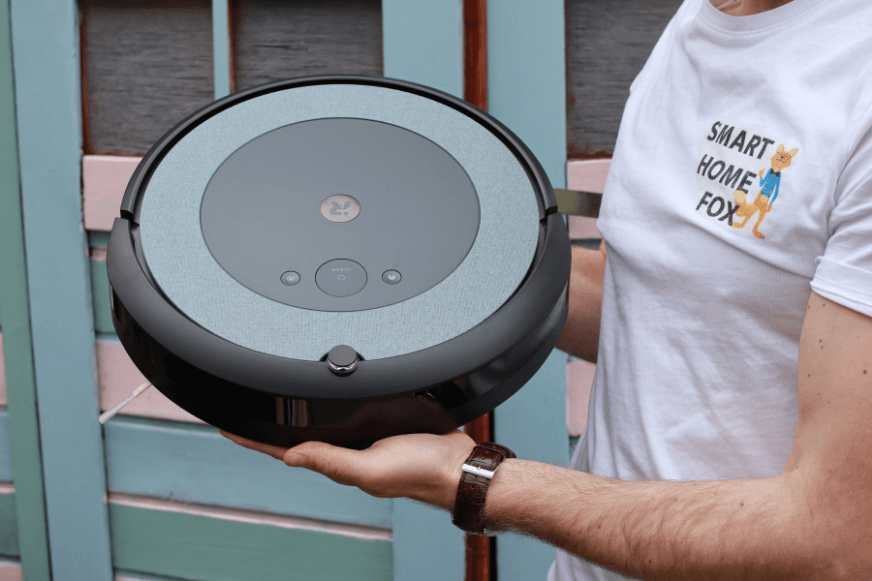 Робот-пылесос держится в руках